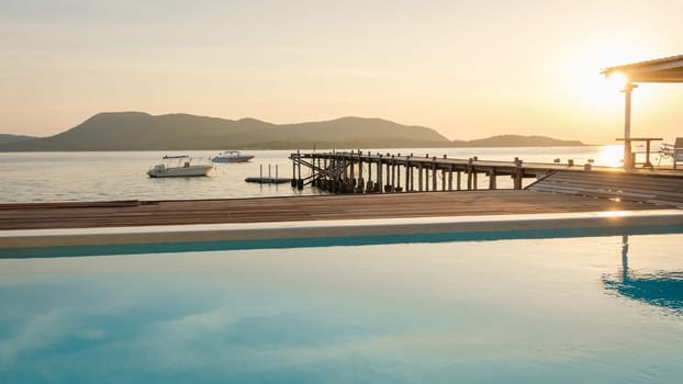 swimming pool and wooden pier in the ocean during sunset in Samaesan Thailand