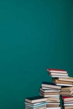 Stack of books on a green background in the library Education