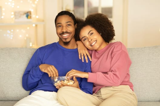 black couple watches movie on TV enjoying evening at home