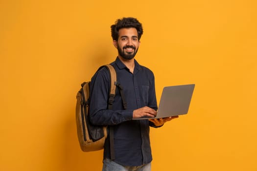 Portrait Of Young Indian Male Student With Backpack And Laptop