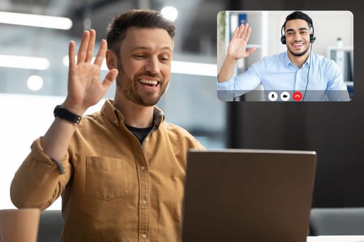 Man Waving Hello To Laptop Making Video Call In Office