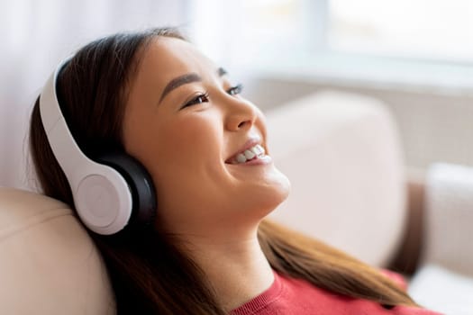Favorite Leisure. Beautiful Smiling Asian Woman Listening Music In Wireless Headphones
