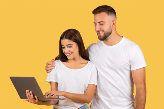 Smiling young european man in white t-shirt hug lady, chatting on computer