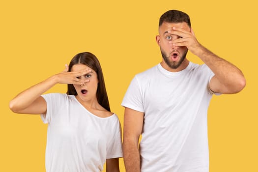 Funny displeased sad young european wife and husband in white t-shirts covers nose
