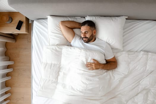 Above view of middle aged man enjoying nap in bedroom