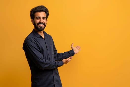 Handsome indian man making presenting gesture with his hand