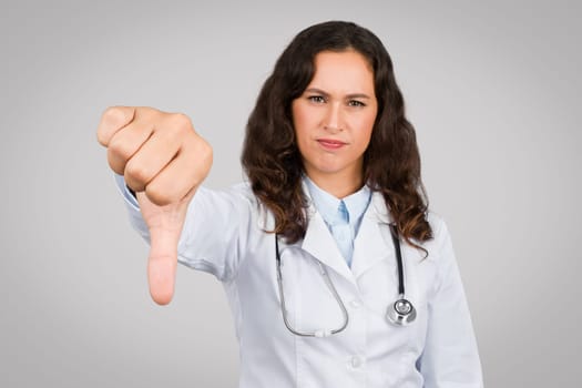 Dissatisfied female doctor giving thumbs down gesture