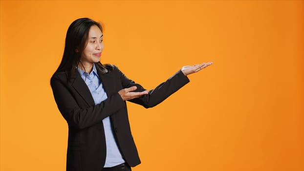 Asian employee points at left or right sides in studio