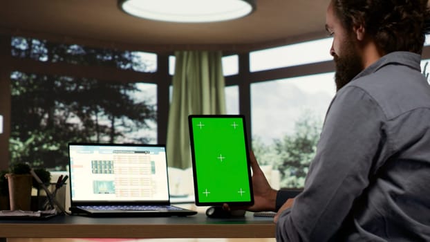 Company CEO examines greenscreen templates on tablet