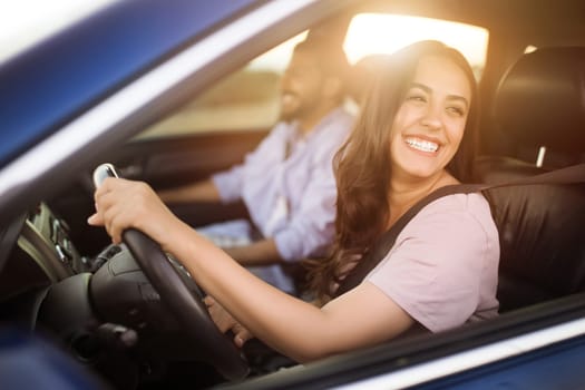 Arab woman driving, laughing with male passenger