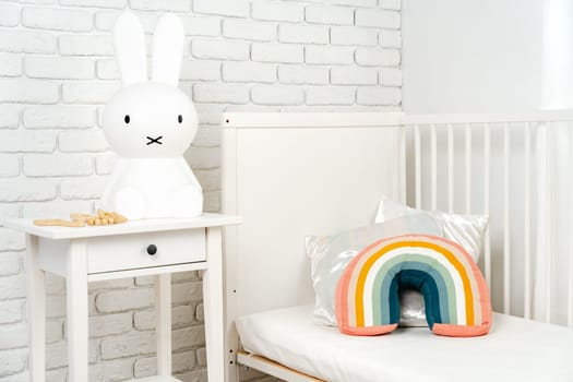 Kid's room interior with comfortable bed and rainbow pillow