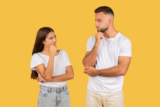 Pensive millennial european wife and husband in white t-shirts think