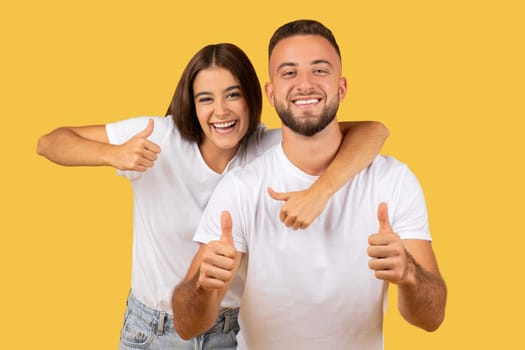Glad millennial european lady hug guy, show thumb up gesture with hands, enjoy free time