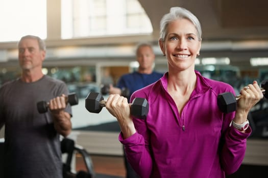 Senior fitness, club and people with dumbbells at gym for training, health and wellness, sport or exercise. Class, workout and elderly group of friends at a studio for bodybuilding or weightlifting