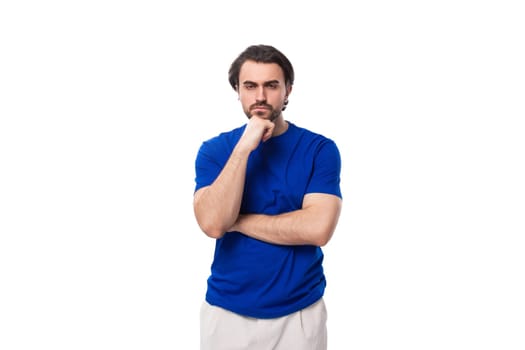 portrait of a young smart caucasian brunette man with a beard in a blue t-shirt thinking about business development. brainstorm
