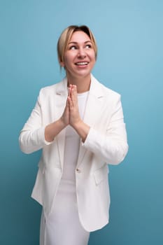 pretty slim young caucasian blondie lady in a white jacket and dress on a plain background