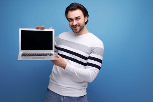 handsome caucasian brunet young man showing laptop screen to insert promotional offer