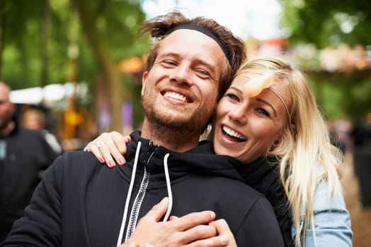 Happy couple, portrait and hug at festival for love, care or support at outdoor party, DJ event or music. Man and woman smile in embrace, affection or trust for festive celebration or summer break.