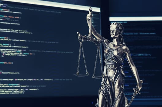 Justice statue with code on screen in background