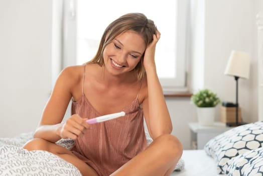 Young happy woman because of the pregnancy test result