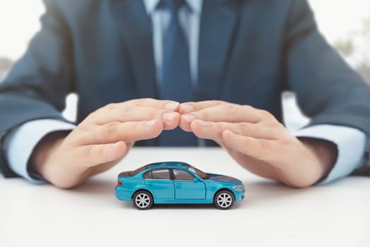 Car insurance, protection and safety concept. Insurance agent protects car with hands.
