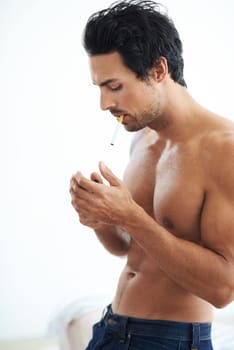 Handsome man, cigarette and smoking for addiction, drag or tobacco against a white studio background. Face of young and attractive male person, model or smoker addict relax shirtless in stress relief