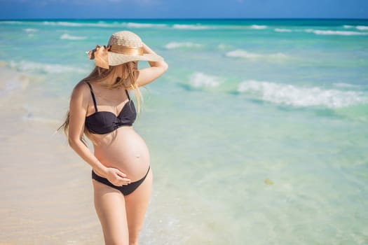 Radiant and expecting, a pregnant woman stands on a pristine snow-white tropical beach, celebrating the miracle of life against a backdrop of natural beauty