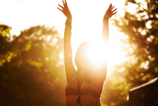 Woman, sunset and outdoor festival for party, event or holiday weekend with arms up in nature freedom. Excited casual female person in celebration for music, concert or sunrise in forest outside.