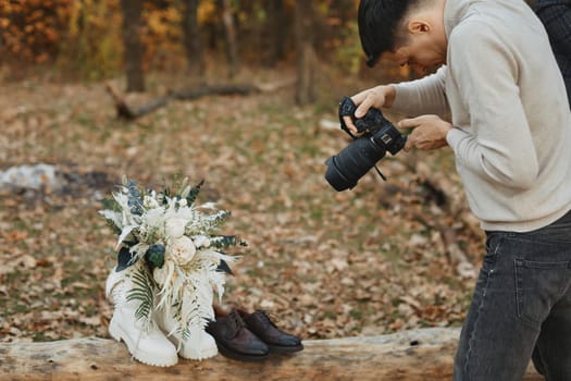 wedding photographer taking pictures of bride and groom shoes, bouquet