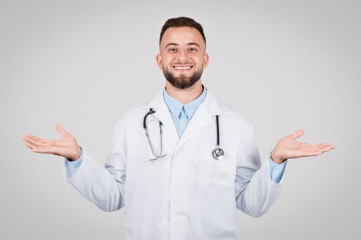 Cheerful male doctor with open hands, ready to assist