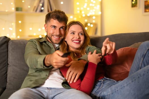 Couple watching TV together, cozy with lights in the background