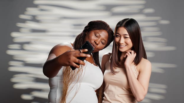 Two skincare models taking photos with smartphone