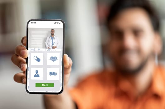 Smiling arab man demonstrating healthcare app on his smartphone