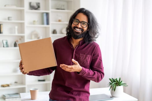 Joyful Young Indian Man Holding Big Cardboard Box At Home,
