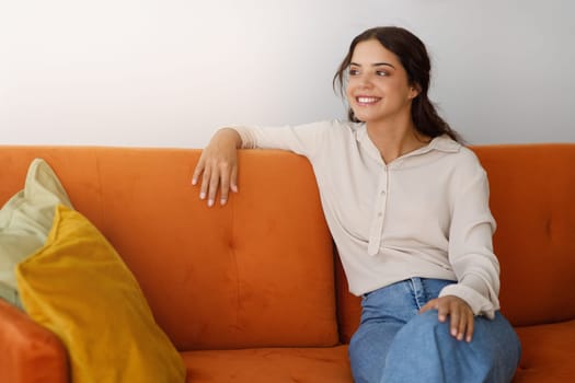Portrait Of Beautiful Smiling Young Woman Relaxing On Comfortable Couch At Home