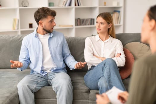 couple having quarrel discussing their marital problems with counselor indoors