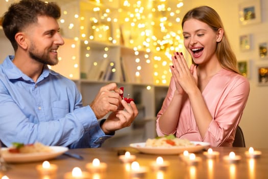 Ecstatic woman reacting to a marriage proposal at a candlelit dinner