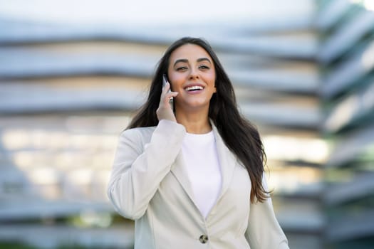 Confident Arabic businesswoman engaging in phone call outdoor