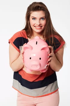 Finance, portrait and woman with piggy bank in studio for savings, payment our budget on white background. Money, box or face of person with cash container for investment or future financial freedom