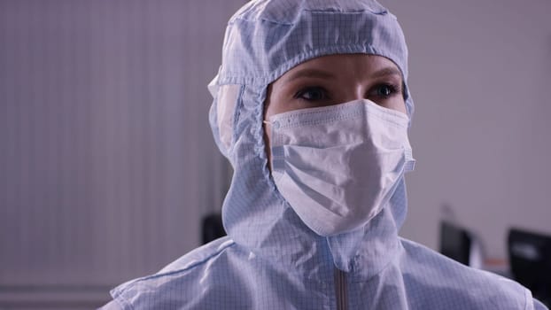 Woman in protective suit afraid of viruses. Female doctor in protective clothes. woman in blue medical protective suit