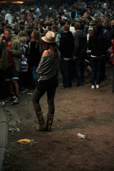 Back, music festival and a woman in the crowd of a concert at night for an event, show or performance. Party, carnival and a person in the audience of a social gathering for live entertainment