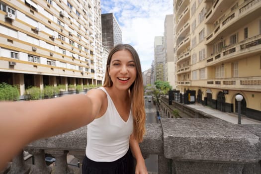 Beautiful smiling girl takes self portrait on Otavio Rocha Viaduct landmark in the city of Porto Alegre, Rio Grande do Sul, Brazil