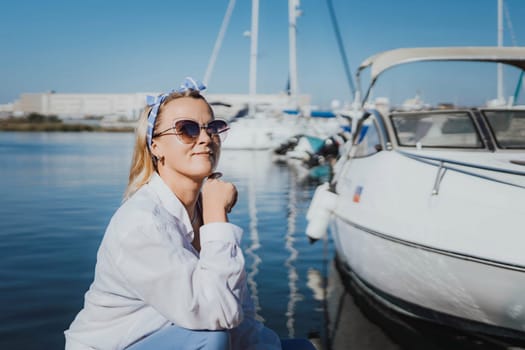 Woman in white shirt in marina , surrounded by several other boats. The marina is filled with boats of various sizes, creating a lively and picturesque atmosphere.