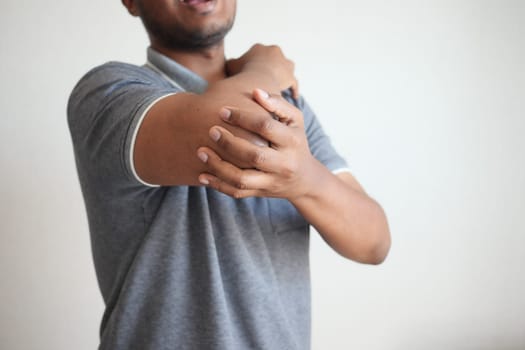 young man suffering pain on elbow