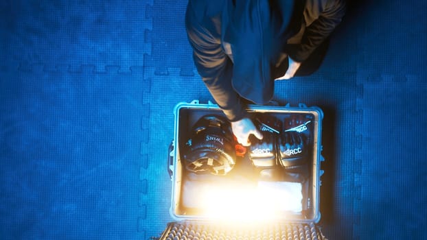 Boxer set. Stock footage. Suitcase with boxing gloves glows when opened. Man opens glowing suitcase with boxing gloves in dark room of sports hall