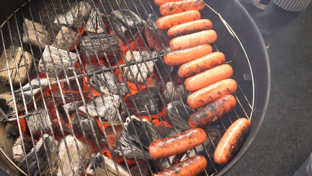 Closeup of sausage on the grill. Sausages are grilled BBQ. Grilled sausage on the flaming grill
