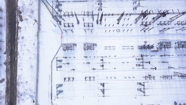 Rows of electric poles of substation. Action. Top view of small electrical substation with rows of transformers in suburbs. Suburban electric substation in winter