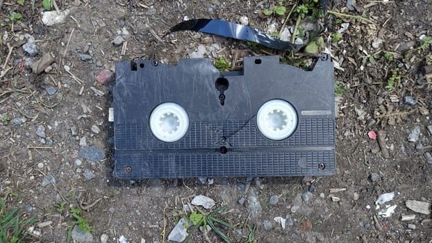 An old broken video cassette abandoned on the ground.