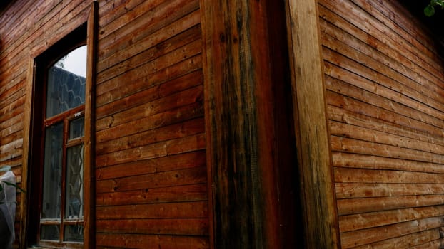 Exterior of a wooden house in the countryside. Stock footage. Traditional residential house with wooden walls.