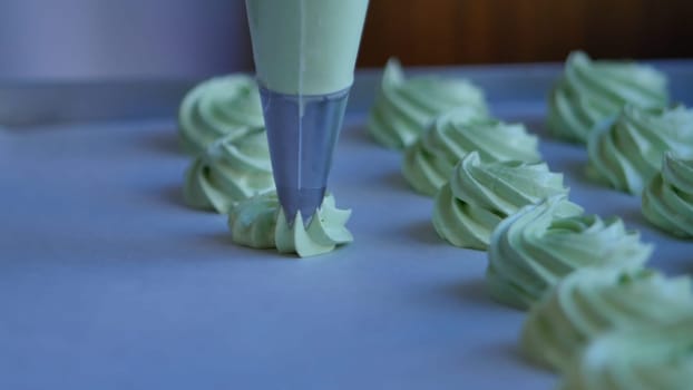 Squeeze the cream filling on the green cupcake, closeup